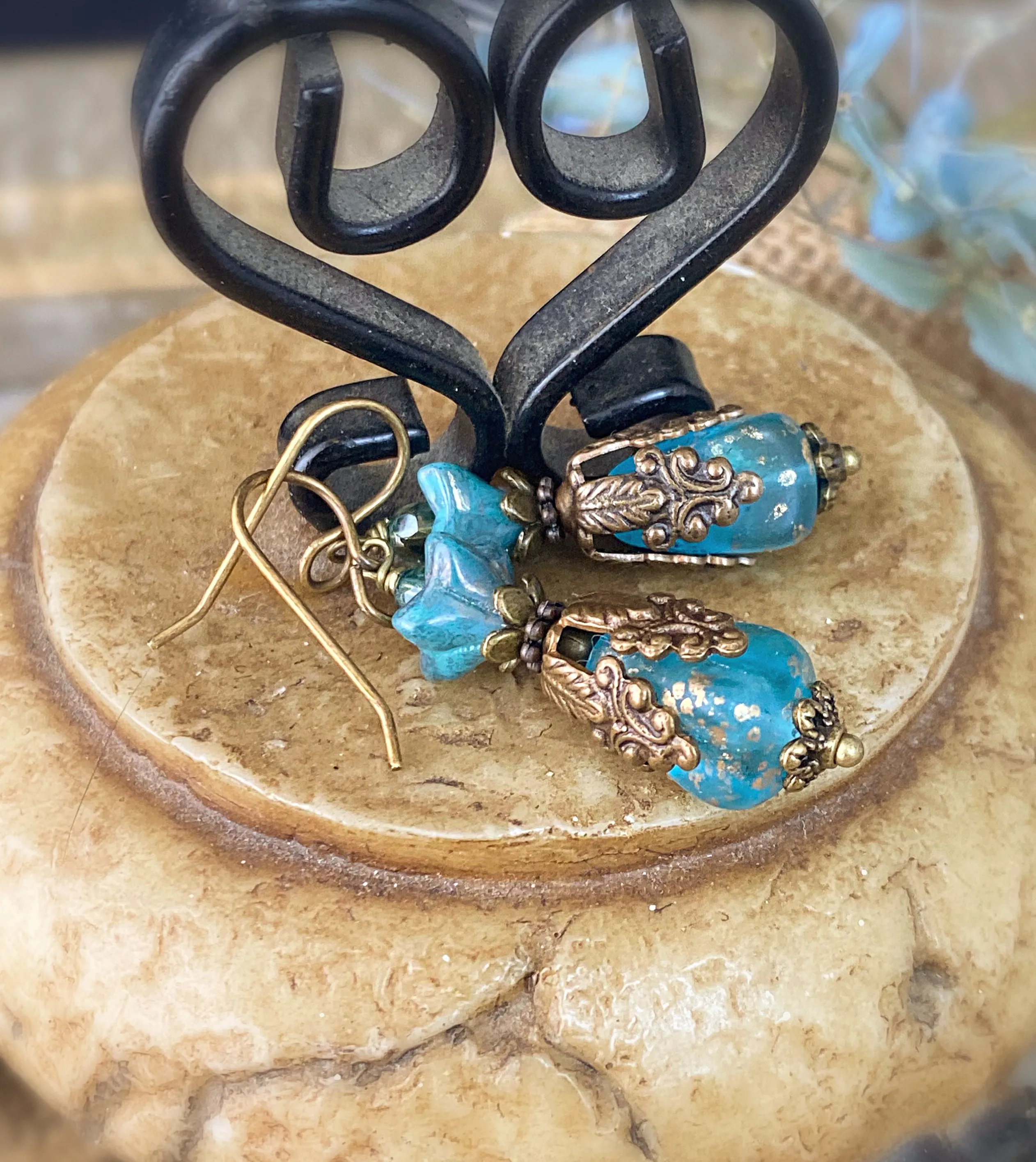 Blue Czech glass, chocolate bronze filigree flower bead caps, and bronze metal earrings.